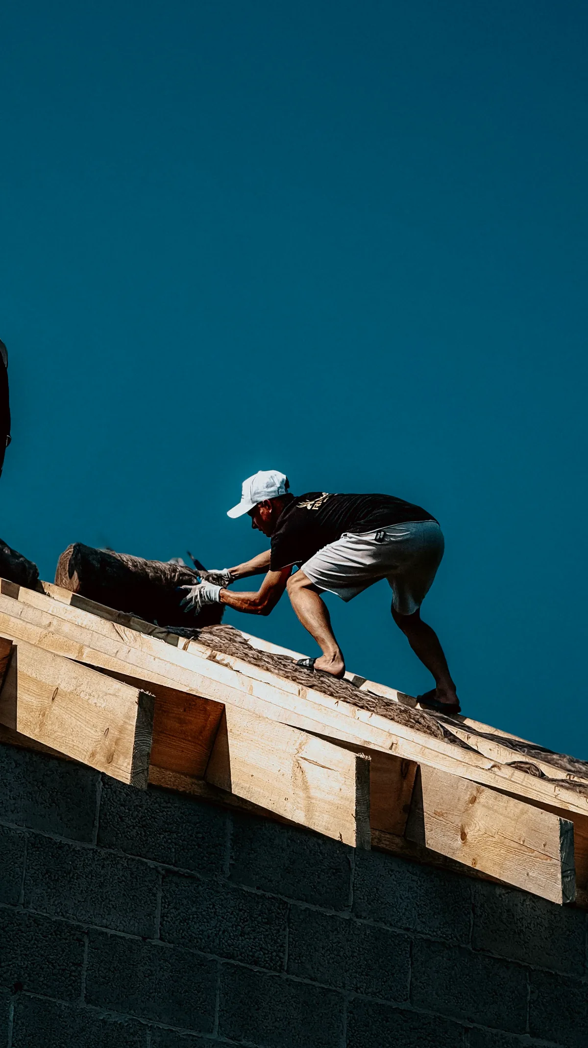 Operario trabajando sobre la estructura de madera de una cubierta, antes de cerrarla